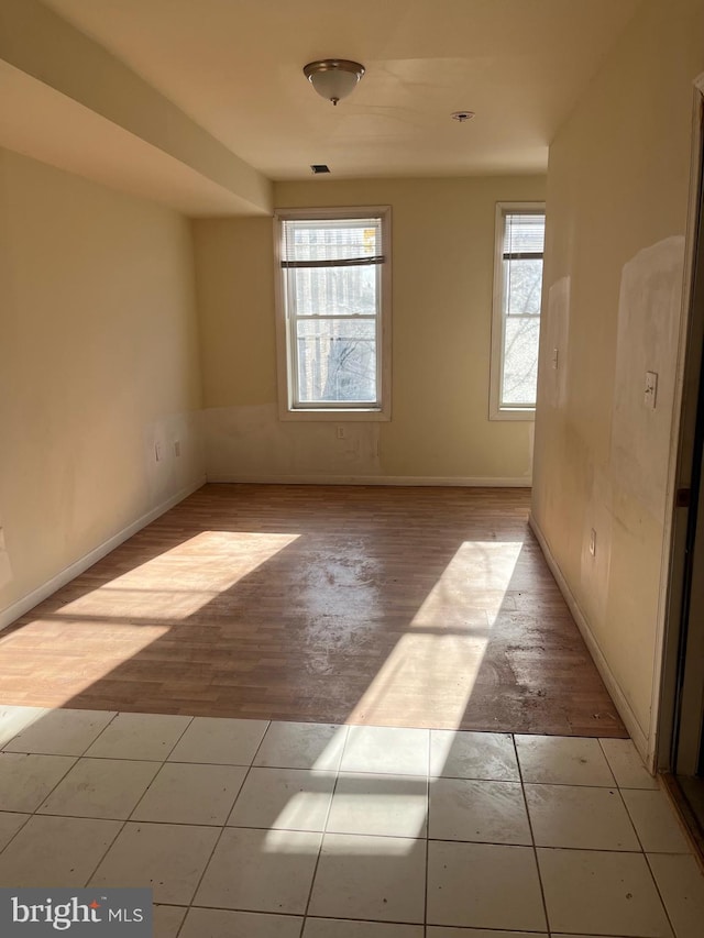 unfurnished room with visible vents, baseboards, and wood finished floors