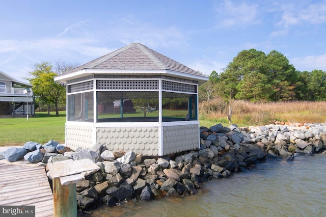 view of property exterior featuring a gazebo, a lawn, and a sunroom