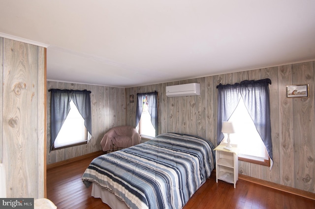 bedroom with baseboards, hardwood / wood-style flooring, and a wall unit AC