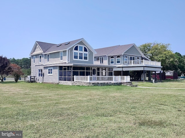 rear view of house with a yard and a sunroom