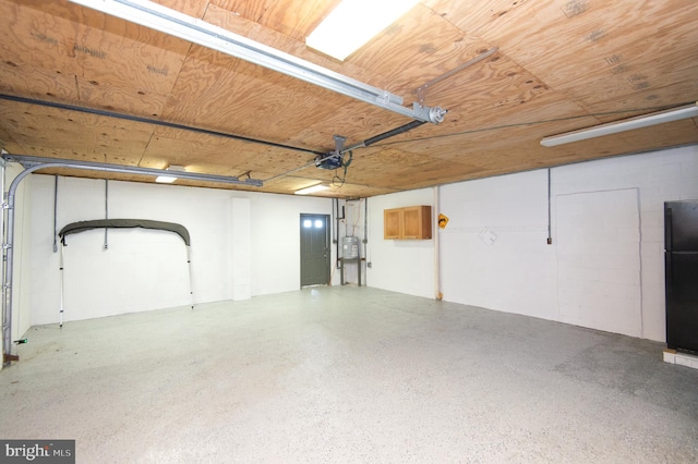 garage featuring a garage door opener, wood ceiling, and freestanding refrigerator