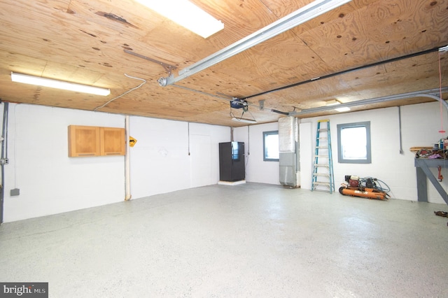 garage with concrete block wall and a garage door opener