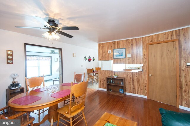 dining area featuring wooden walls and wood finished floors