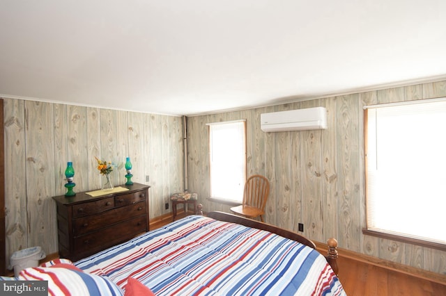 bedroom featuring an AC wall unit and wood finished floors