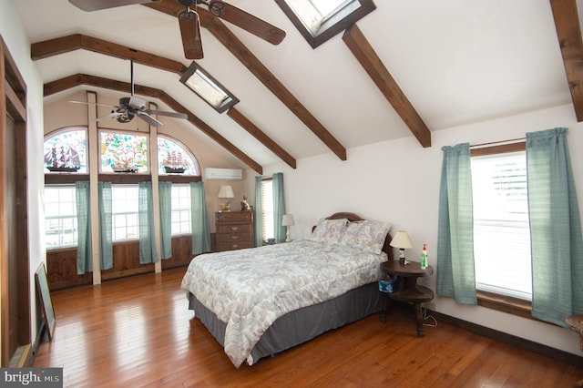 bedroom with multiple windows, wood finished floors, and vaulted ceiling with skylight