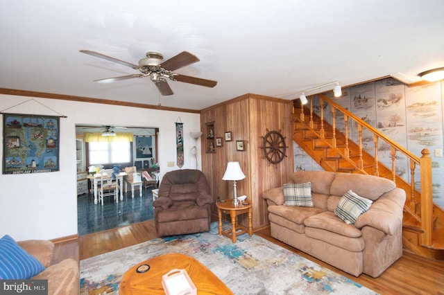 living room featuring a ceiling fan, stairway, wood finished floors, and ornamental molding