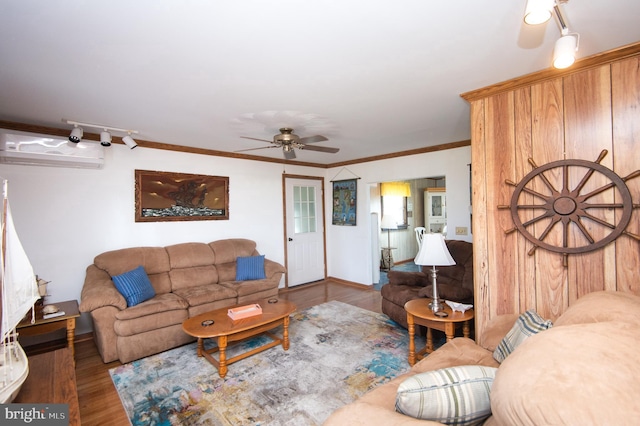 living room with baseboards, an AC wall unit, ornamental molding, a ceiling fan, and wood finished floors