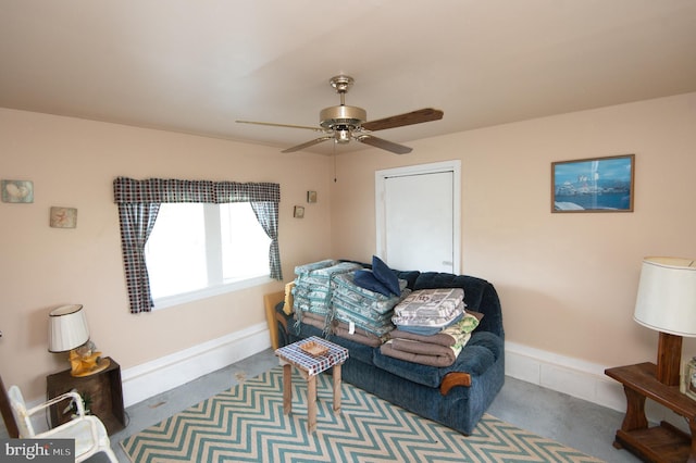 living area featuring baseboards and a ceiling fan