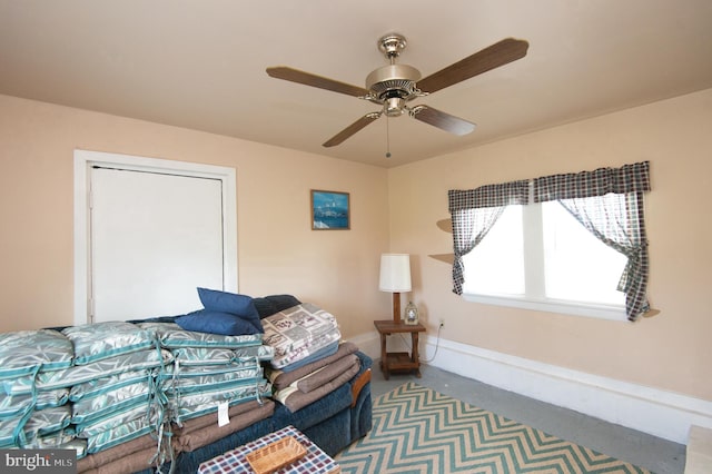 carpeted living room with baseboards and a ceiling fan