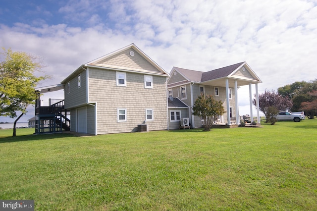 back of house featuring stairway, central air condition unit, a lawn, and a garage