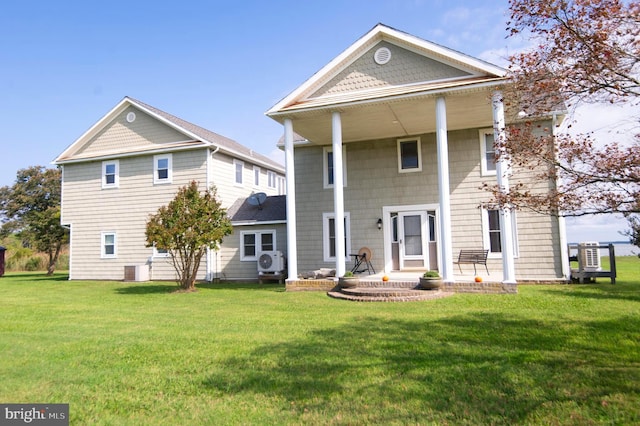 view of front of house with a front yard and ac unit