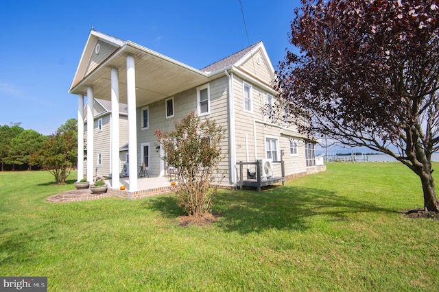 view of property exterior with a patio and a lawn