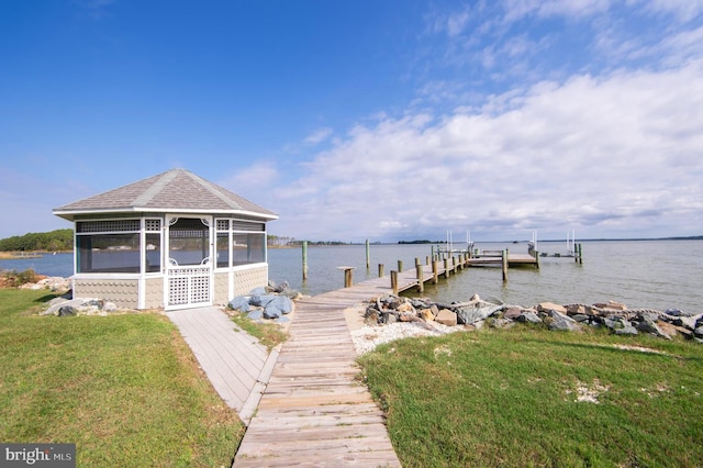 view of dock with a water view and a lawn