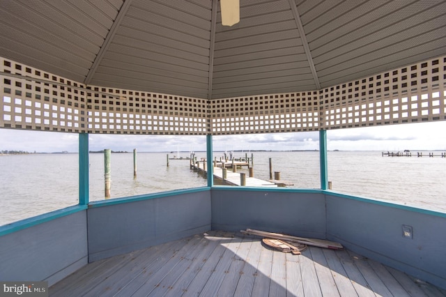 wooden deck with a dock and a water view