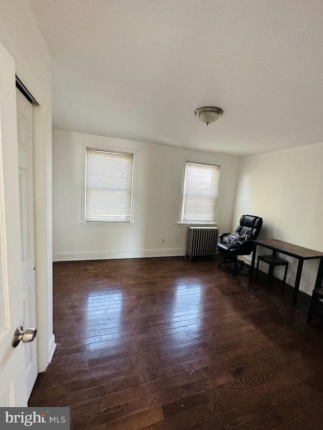 sitting room featuring dark hardwood / wood-style floors and radiator heating unit