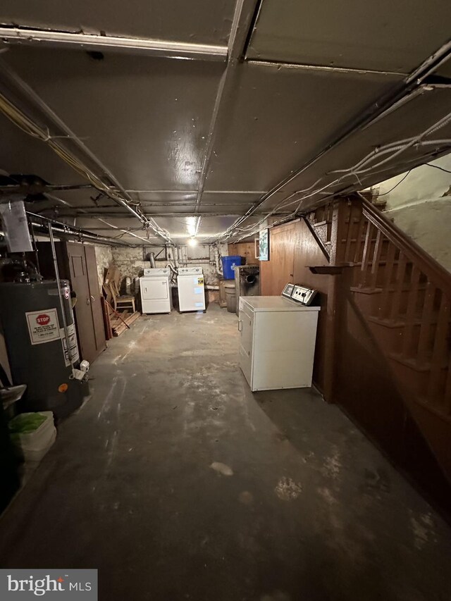 basement featuring water heater and independent washer and dryer