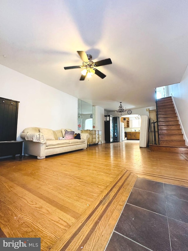 living area featuring stairway, wood finished floors, and ceiling fan