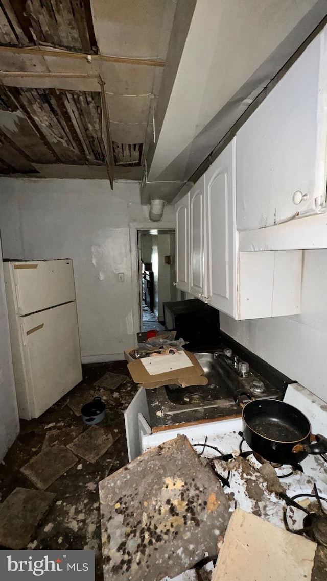 kitchen featuring white cabinetry and white fridge