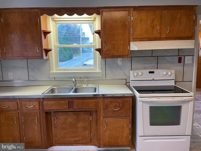 kitchen featuring electric stove, a sink, open shelves, under cabinet range hood, and light countertops