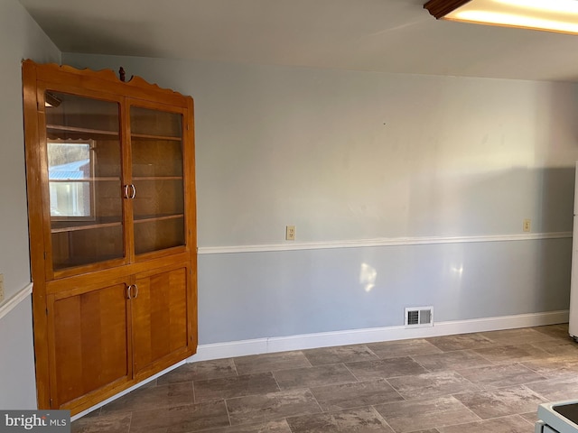 spare room with baseboards and visible vents