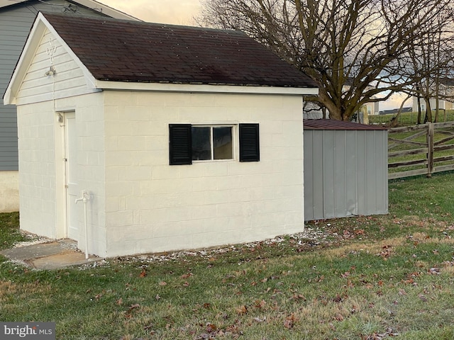 view of outbuilding featuring an outdoor structure and fence