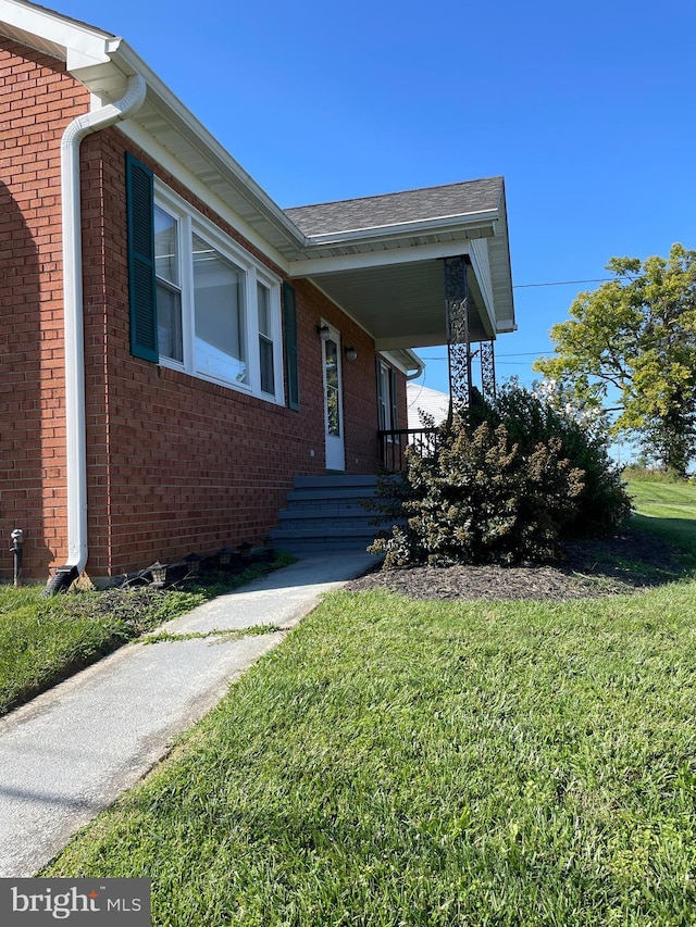 view of front of home featuring brick siding and a front lawn