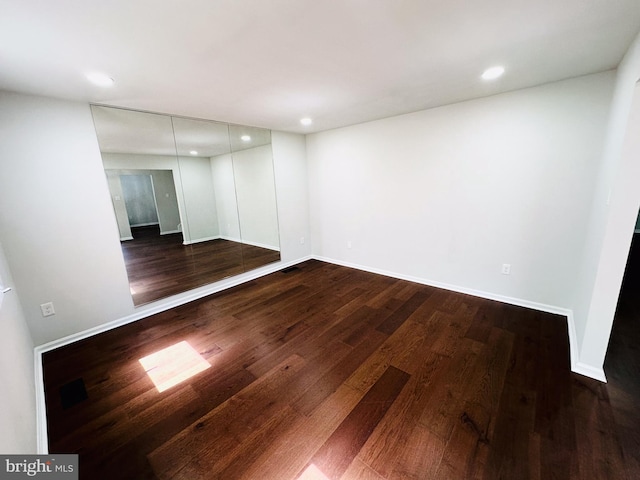 spare room with dark hardwood / wood-style flooring