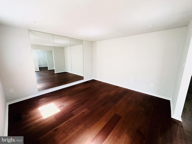 empty room with dark hardwood / wood-style flooring