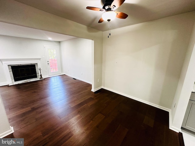 unfurnished living room with ceiling fan and dark wood-type flooring