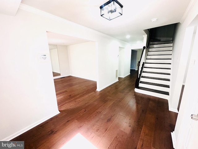 stairs with ornamental molding and hardwood / wood-style floors