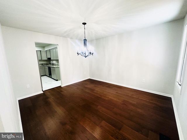 unfurnished dining area featuring an inviting chandelier and dark wood-type flooring