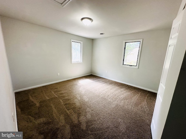 unfurnished room featuring dark carpet