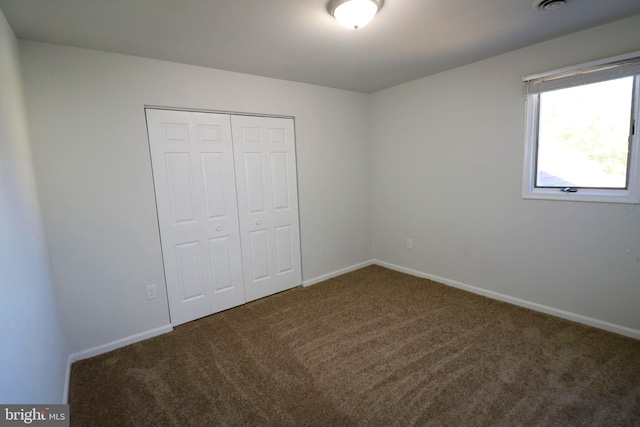 unfurnished bedroom with a closet and carpet flooring