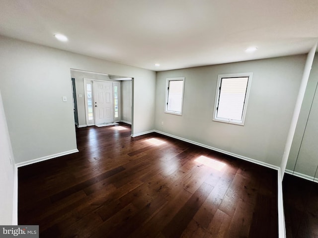 unfurnished room with dark wood-type flooring