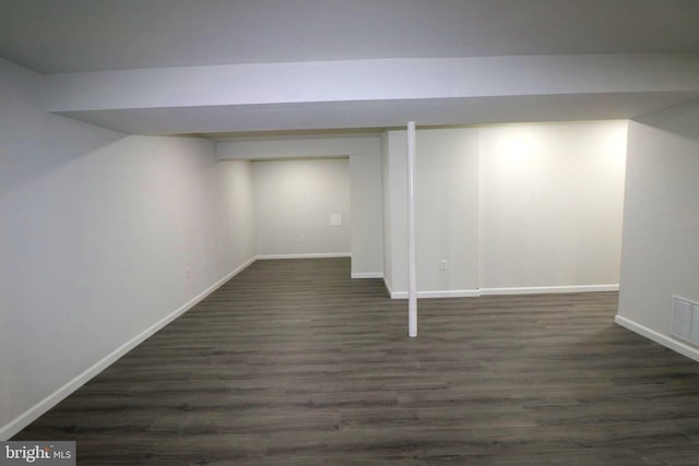 basement with dark hardwood / wood-style flooring