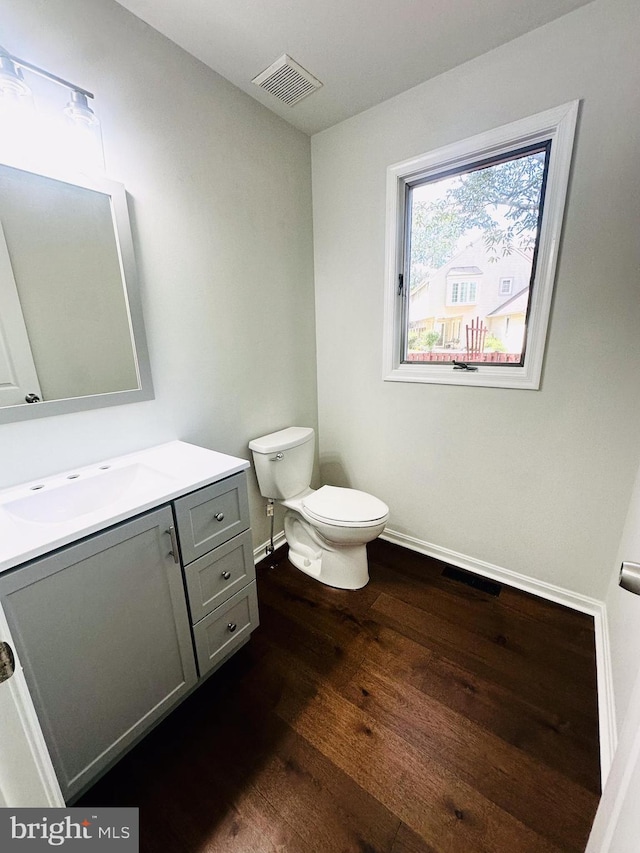 bathroom with wood-type flooring, vanity, and toilet