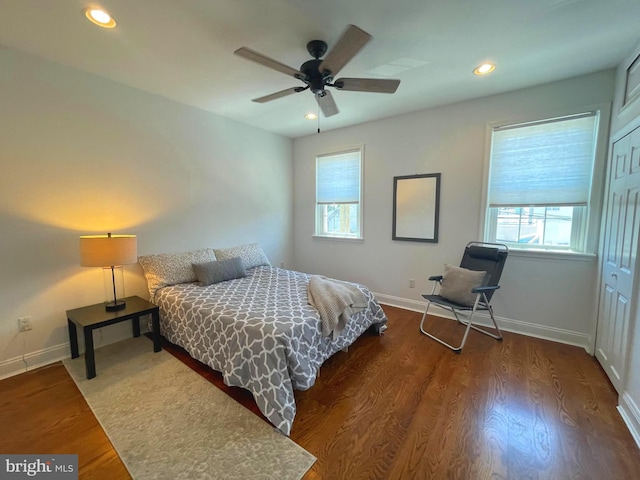 bedroom featuring ceiling fan, dark hardwood / wood-style floors, and a closet