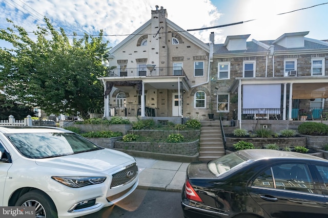 multi unit property featuring a balcony and covered porch