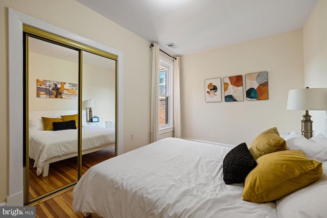 bedroom with dark wood-type flooring and a closet