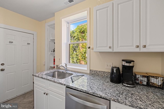 kitchen with stainless steel dishwasher, light stone counters, sink, and white cabinets