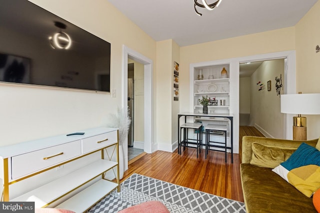 living room featuring built in features and hardwood / wood-style floors