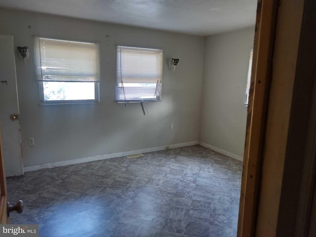 unfurnished room featuring tile patterned floors and baseboards