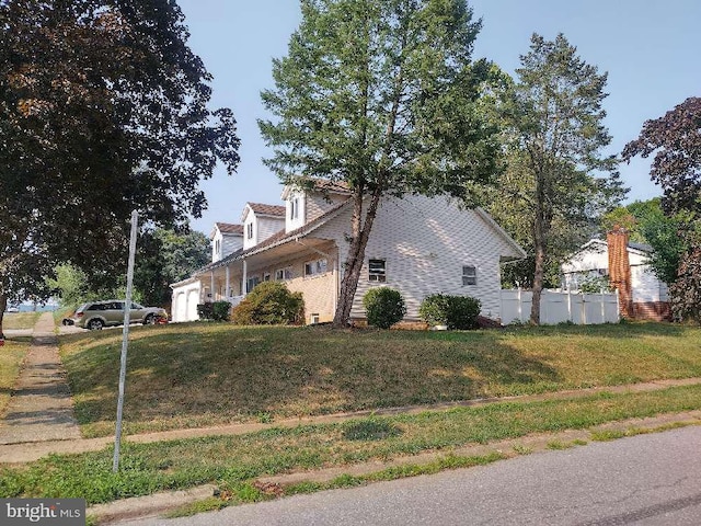 view of side of home featuring a garage, a yard, and fence