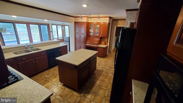 kitchen featuring black appliances, ornamental molding, sink, and a kitchen island