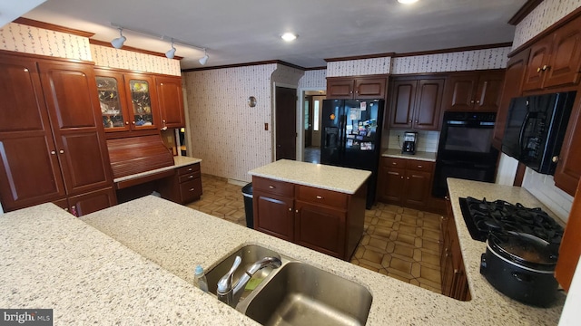 kitchen with light stone countertops, black appliances, crown molding, and sink