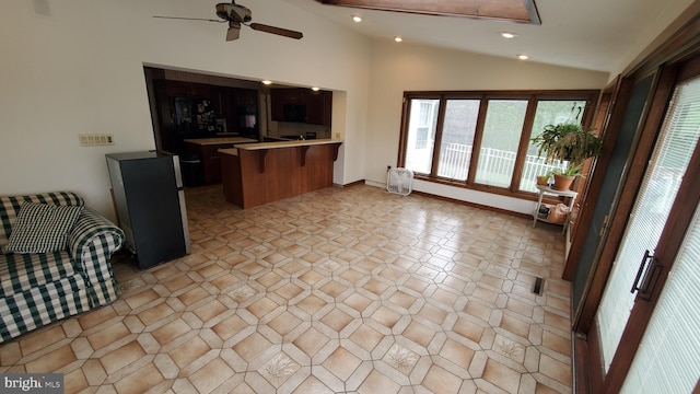 kitchen featuring a kitchen breakfast bar, vaulted ceiling, kitchen peninsula, and ceiling fan