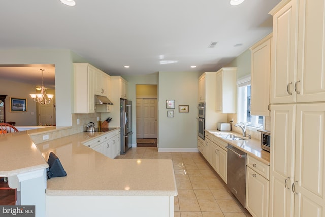 kitchen featuring extractor fan, kitchen peninsula, sink, pendant lighting, and appliances with stainless steel finishes