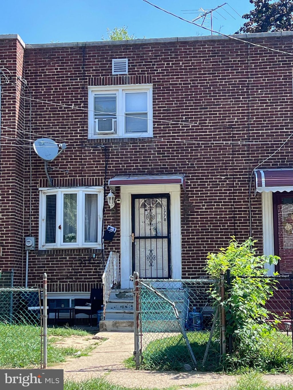 view of property with fence and brick siding