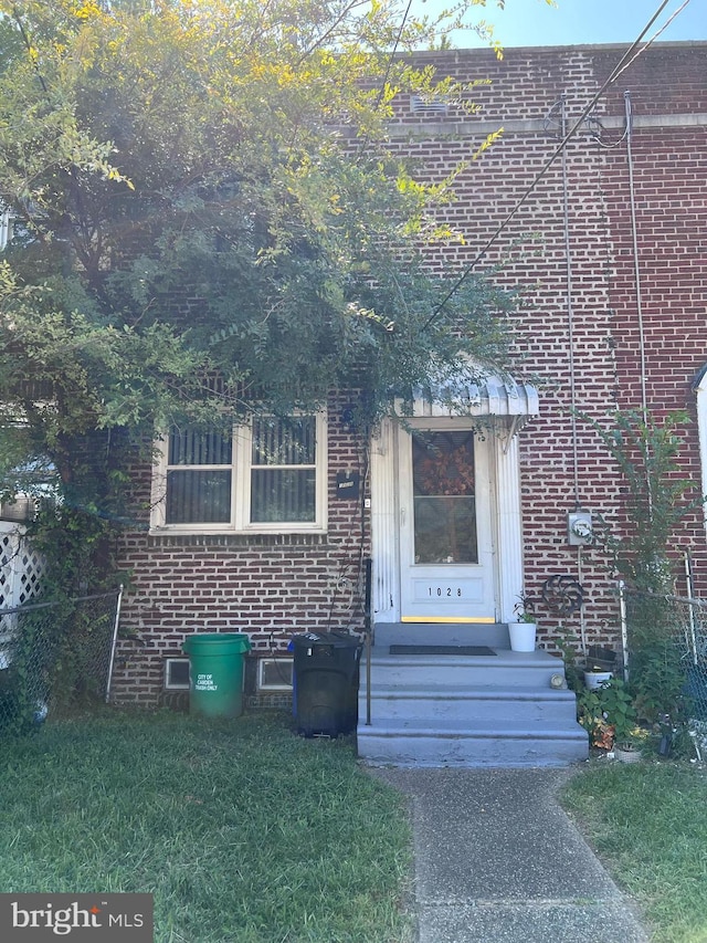 view of front of house featuring brick siding, a front yard, and entry steps