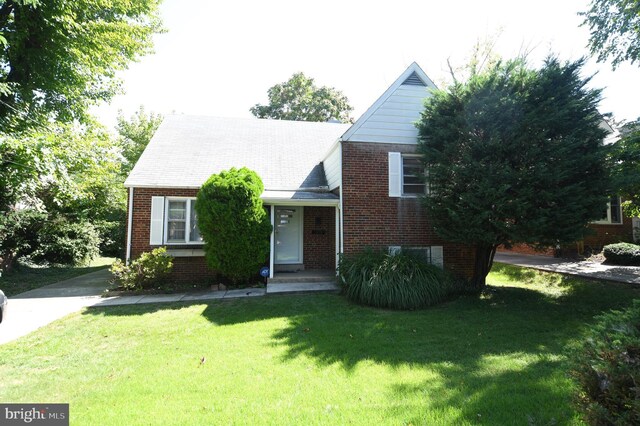 view of front facade with brick siding and a front yard